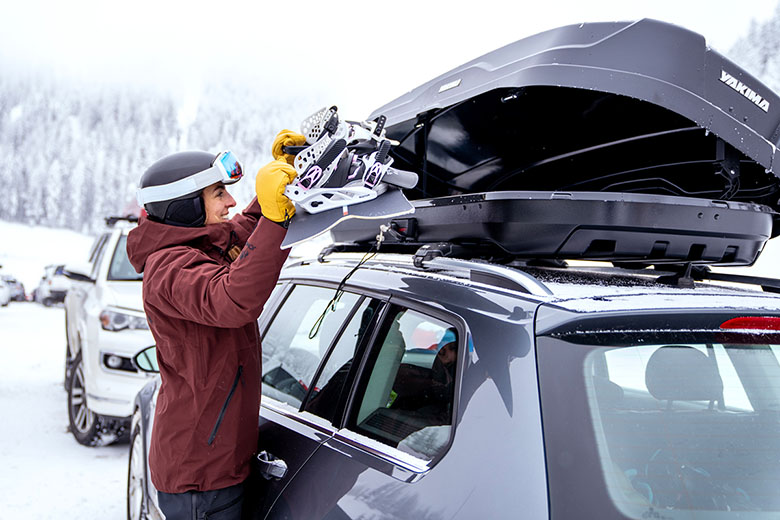 Yakima SkyBox NX 16 roof box (putting snowboard in box)